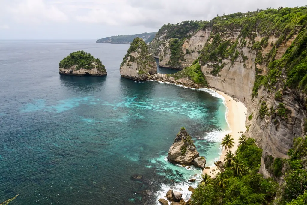 Diamond Beach op Nusa Penida met wit zandstrand, kalkstenen kliffen en rotseilandjes in turquoise zee