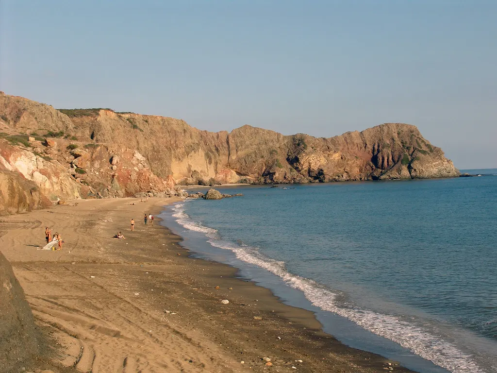 Zandstrand van Paliochori met kleurrijke vulkanische kliffen en kalme blauwe zee op Milos