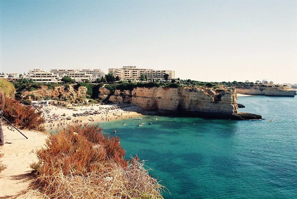 Zandstrand Senhora da Rocha met gele kliffen, turquoise zee en hotels op de rotsen