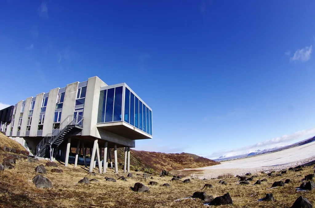 Het moderne ION Hotel op betonnen palen in het IJslandse lavalandschap onder een strakblauwe lucht