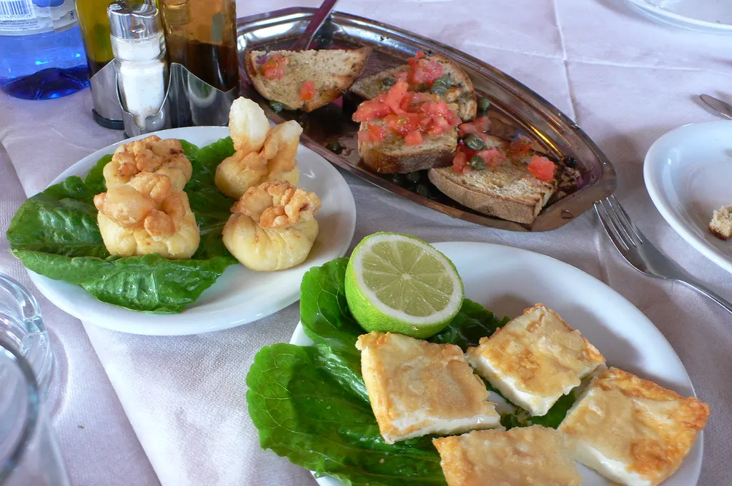 Griekse voorgerechten met gebakken kaas, bruschetta en deeghapjes op een gedekte restauranttafel