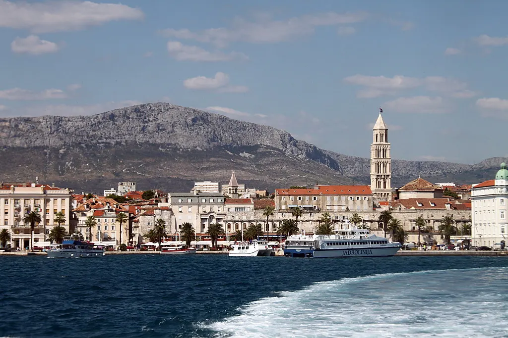 Uitzicht vanaf een boot op de kust van Split met de klokkentoren van het Diocletianuspaleis en bergen