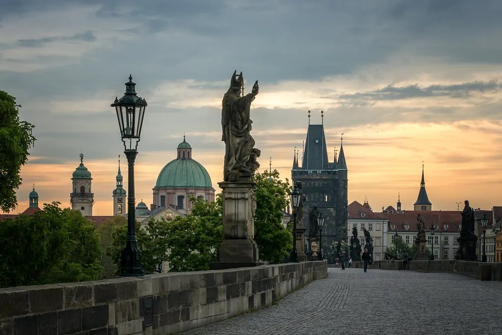 Karelsbrug in Praag bij zonsopkomst met beelden, lantaarns en de Oude Stadsbrugtoren