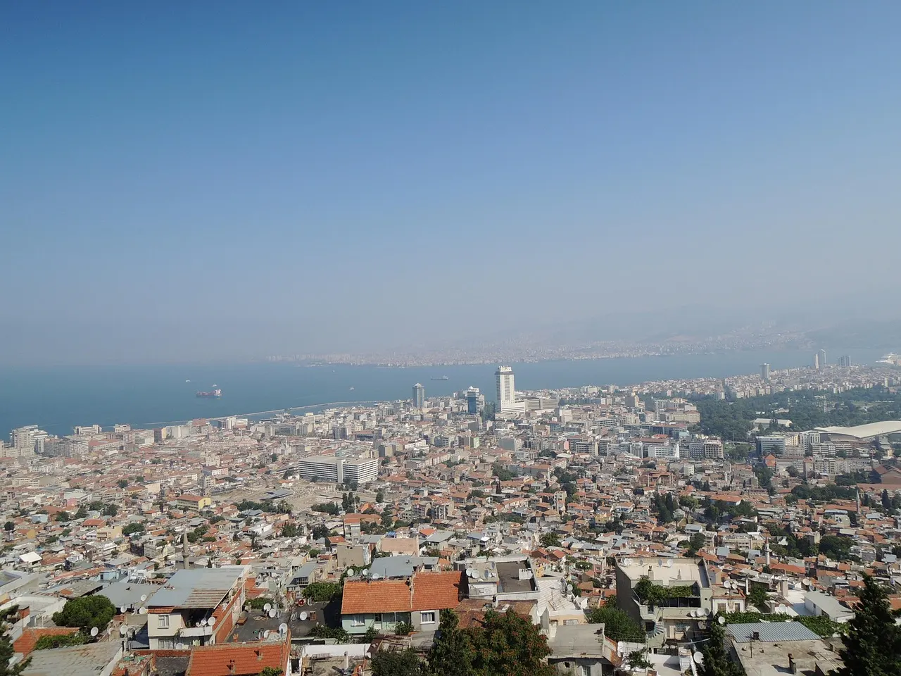 Uitzicht vanaf een heuvel over de dicht bebouwde stad Izmir met de baai op de achtergrond