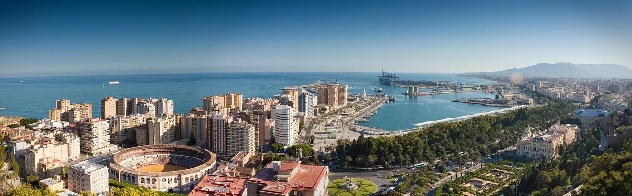 Panorama van Malaga met de arena La Malagueta, de haven en de Middellandse Zee onder een blauwe lucht