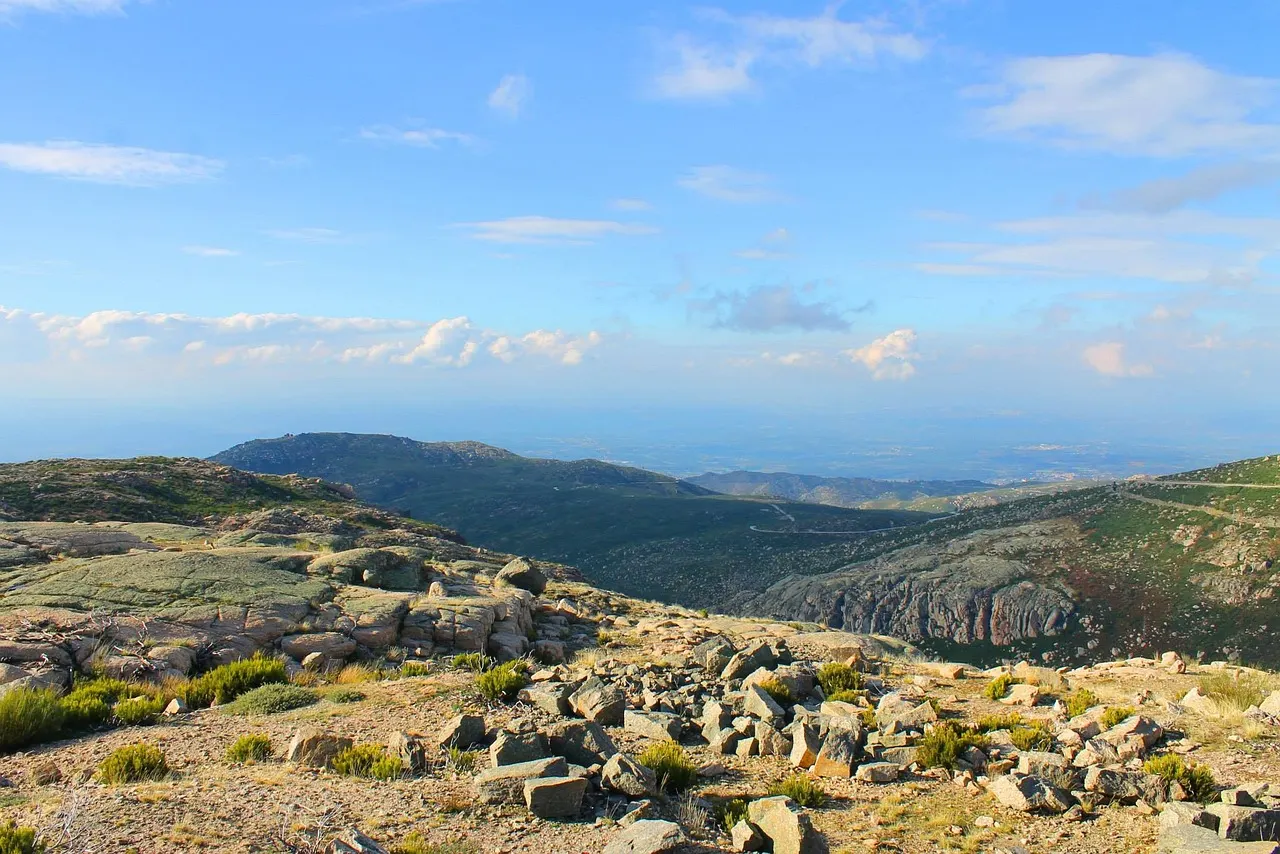 Rotsachtig berglandschap van de Serra da Estrela met glooiende heuvels en weids uitzicht onder blauwe lucht