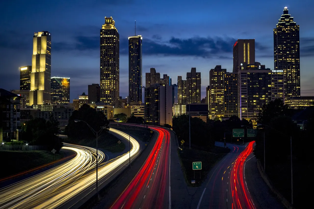 Verlichte skyline van Atlanta in de avond met lichtsporen van verkeer op de snelweg
