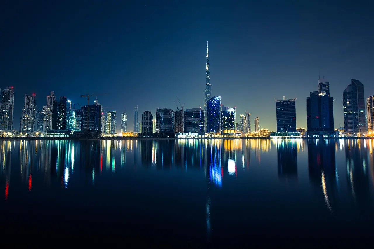 Skyline van Dubai bij nacht met de Burj Khalifa, weerspiegeld in het water