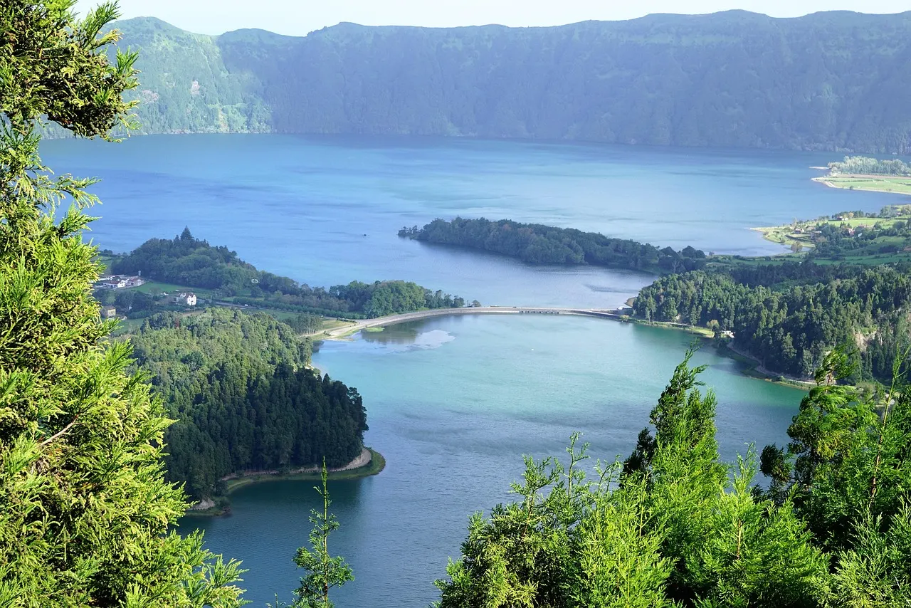 Uitzicht op de blauwe en groene kratermeren van Sete Cidades met de brug ertussen, omringd door kraterwanden
