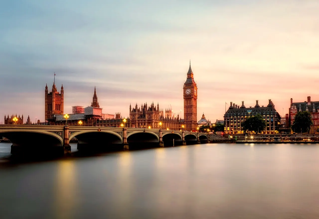 Big Ben en de Houses of Parliament met Westminster Bridge over de Theems bij zonsondergang in Londen