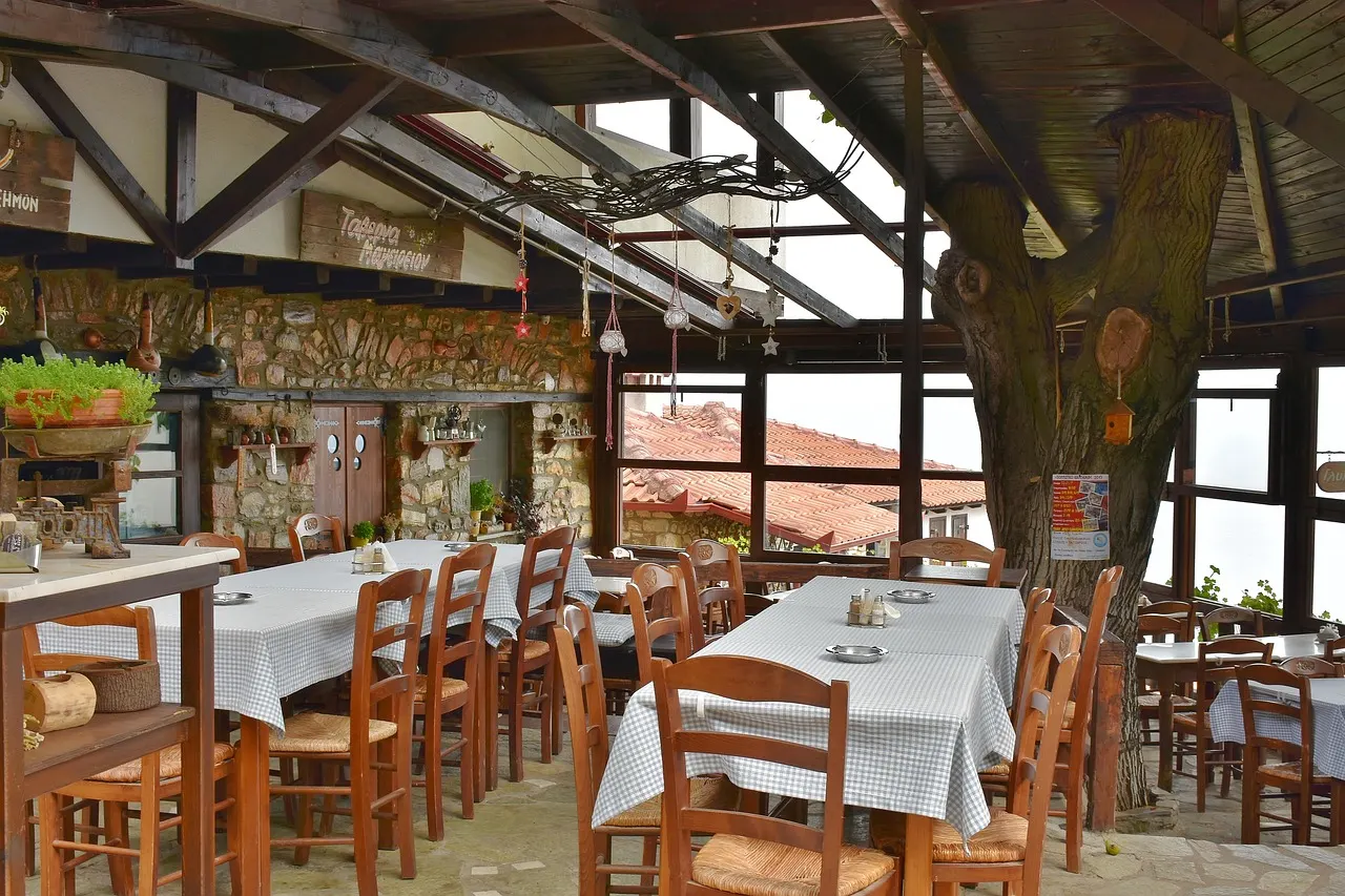Gezellig Grieks restaurant met houten balken, rieten stoelen en tafels met geruite tafelkleden