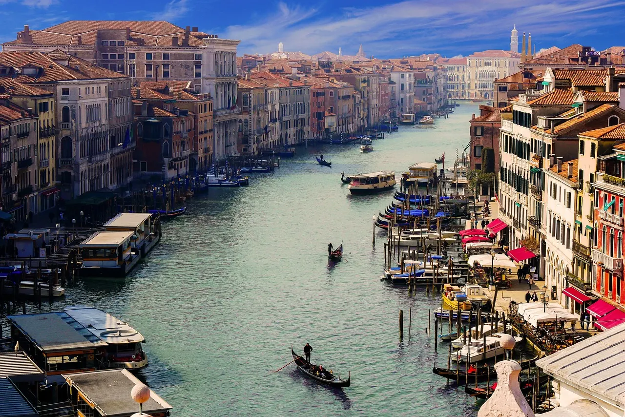 Uitzicht over het Canal Grande in Venetië met gondels, boten en kleurrijke palazzi langs het water