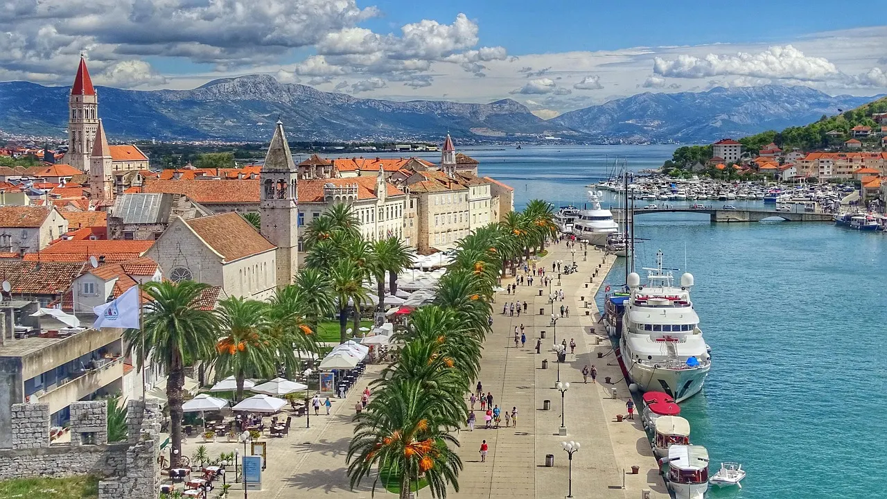 Uitzicht over de oude stad van Trogir met kerktorens, palmenboulevard en jachten aan de kade