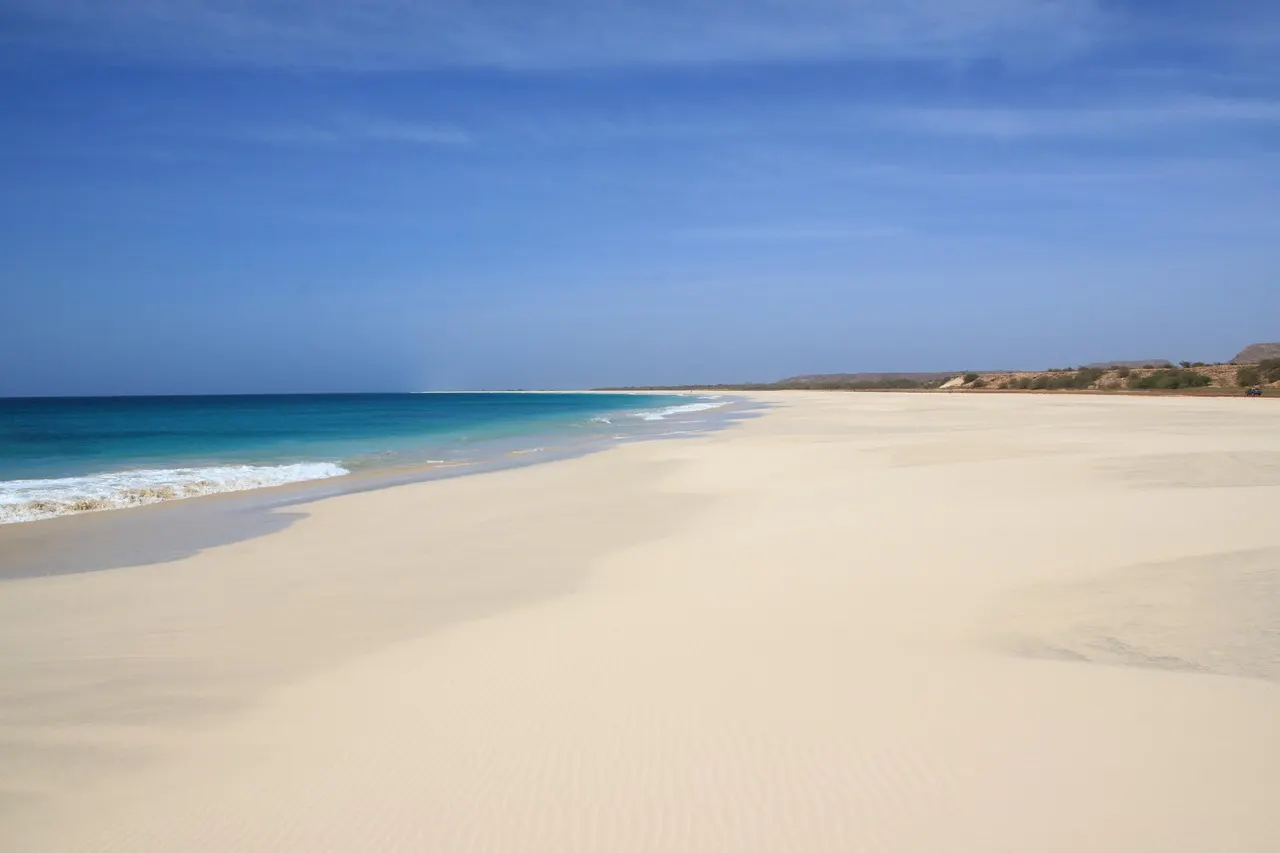 Breed wit zandstrand met turquoise zee en strakblauwe lucht op Kaapverdië