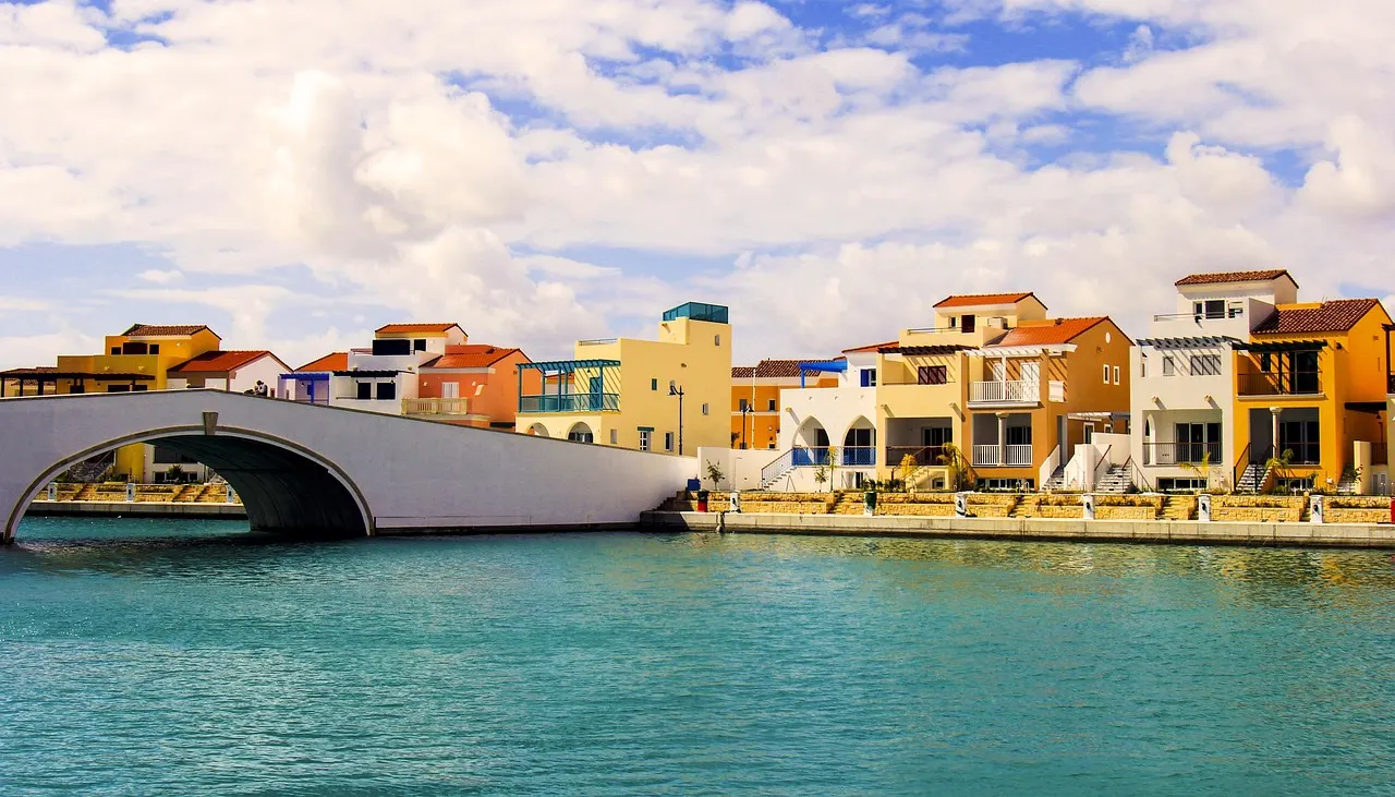 Kleurrijke huizen en een witte brug aan het turquoise water van de jachthaven van Limassol