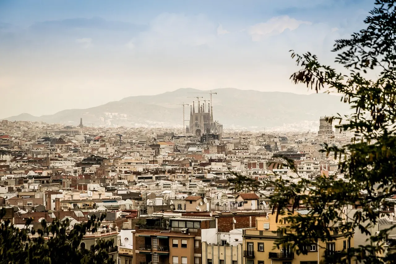 Uitzicht over de daken van Barcelona met de Sagrada Família en de bergen op de achtergrond