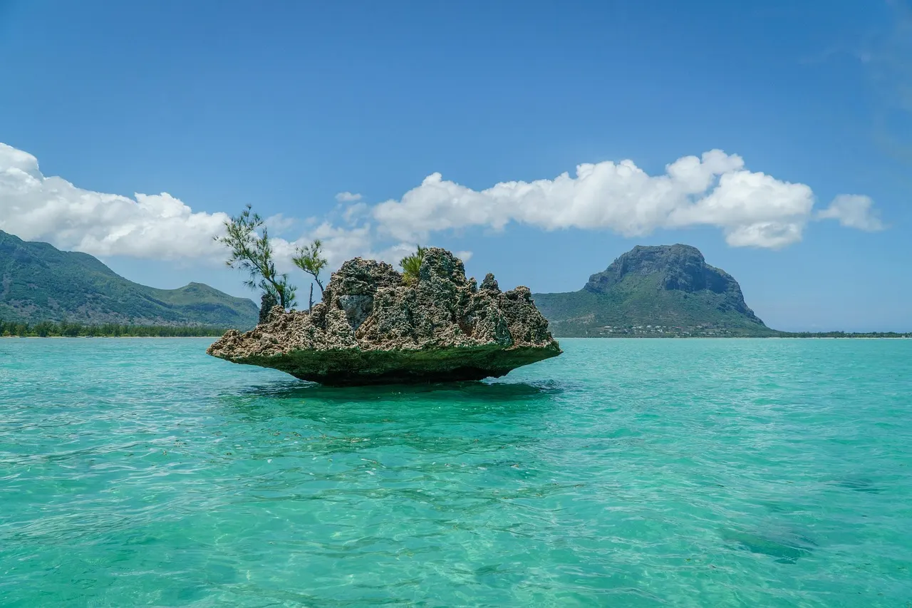 Crystal Rock in turquoise lagune met de Le Morne-berg op de achtergrond onder blauwe lucht