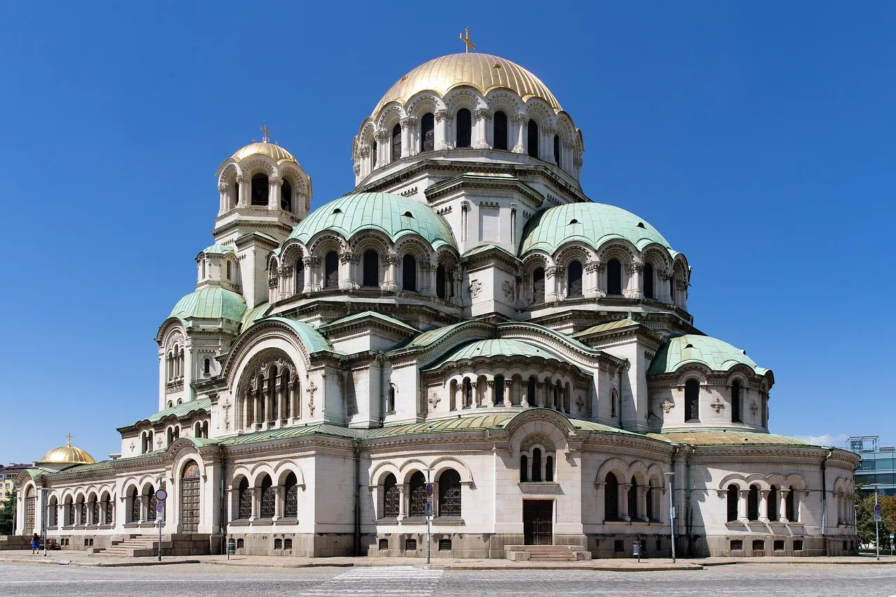 De Alexander Nevski-kathedraal in Sofia met gouden en groene koepels onder een strakblauwe lucht
