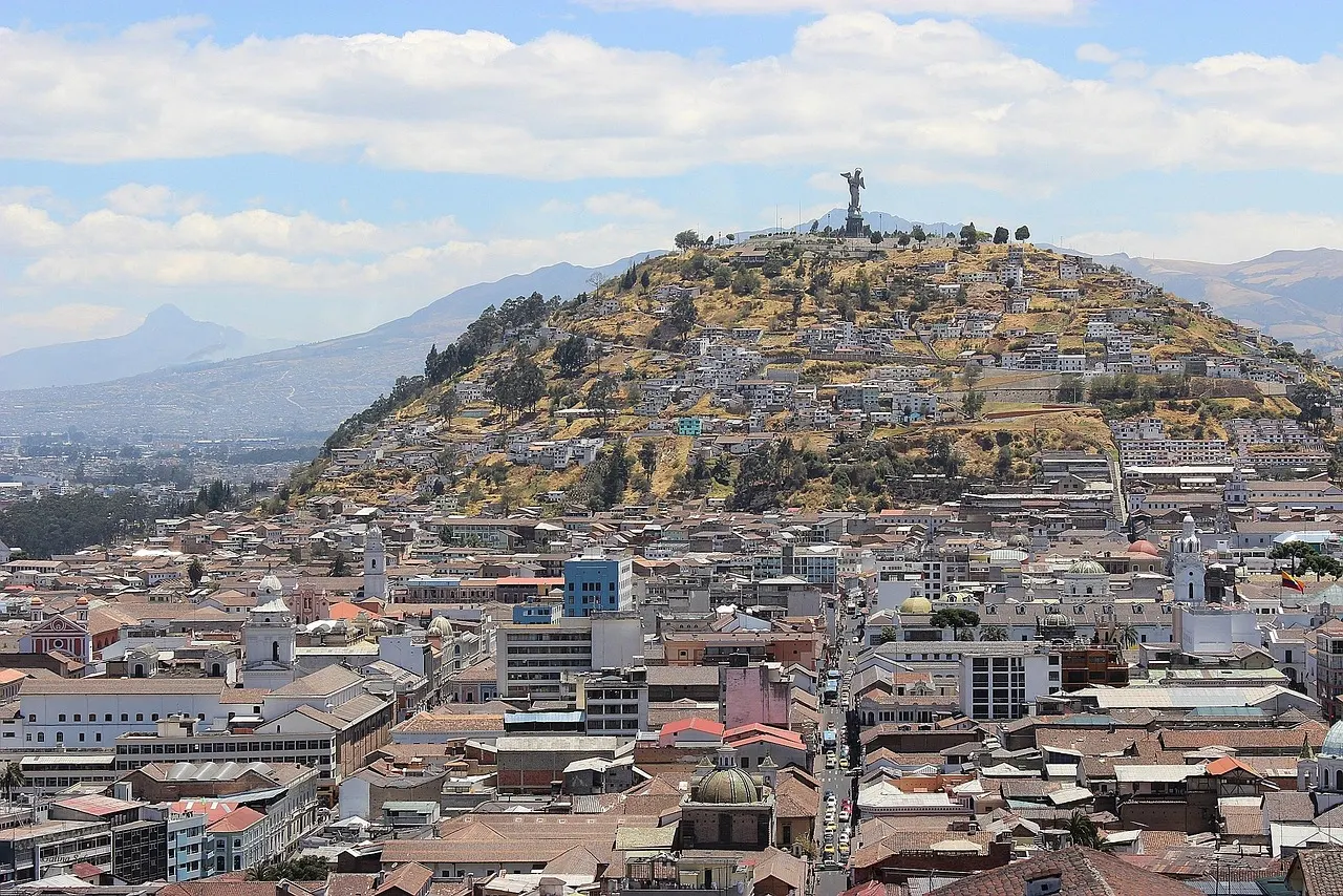 Uitzicht over de daken van Quito met de heuvel El Panecillo en de bergen op de achtergrond
