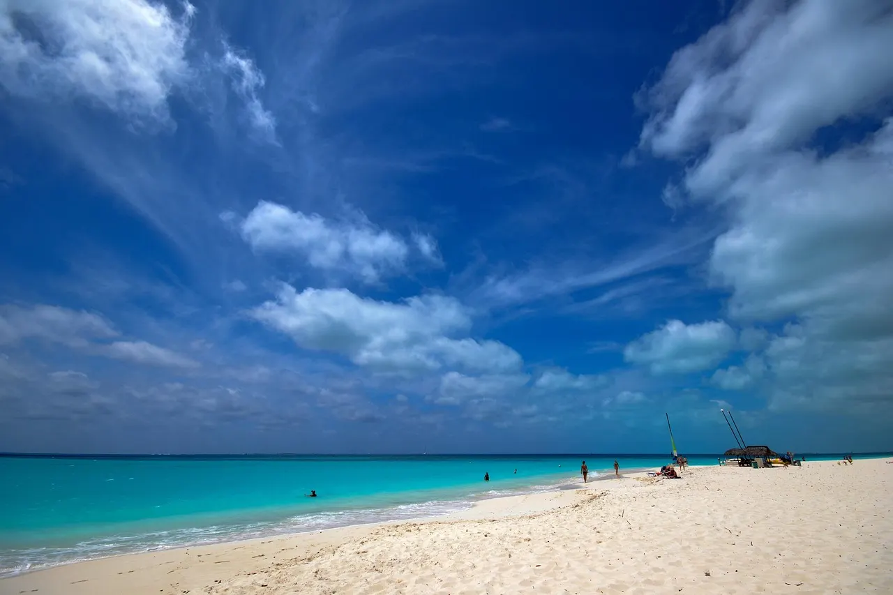 Wit zandstrand met turquoise zee en wolkenlucht op Playa Paraiso, Cayo Largo
