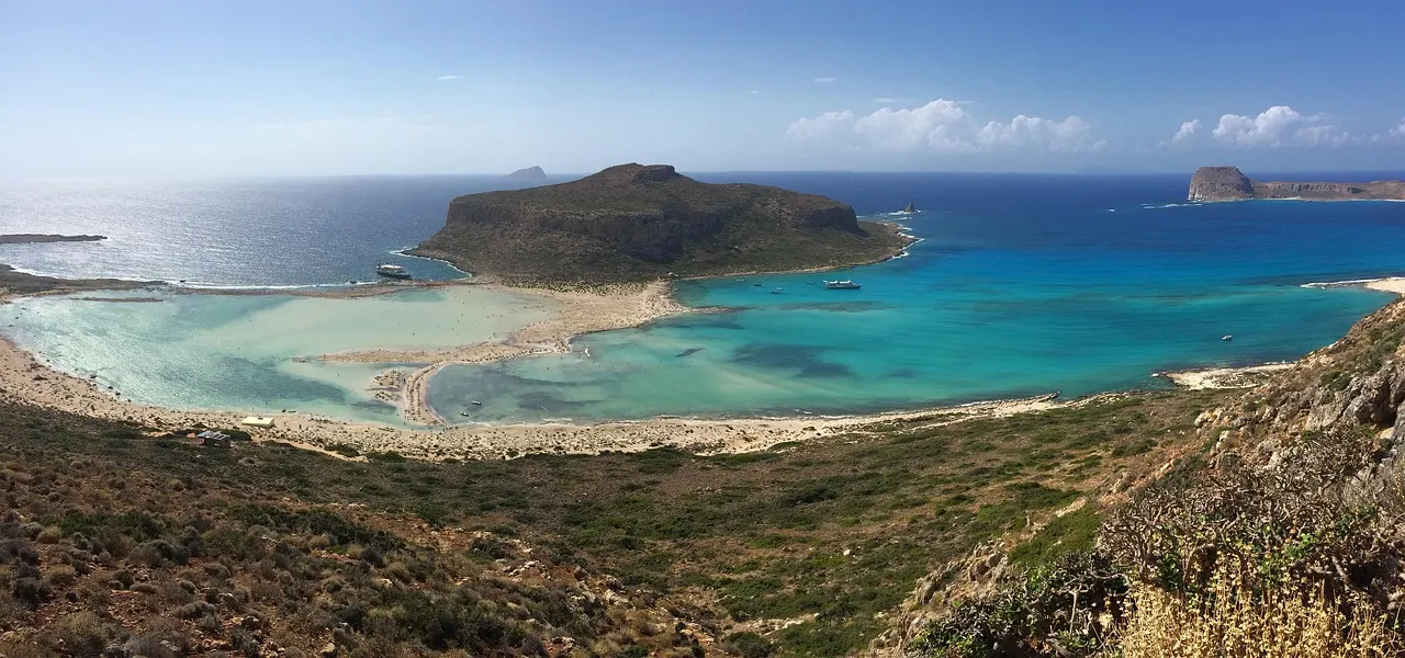 Uitzicht vanaf de heuvel op de turquoise lagune van Balos met het eiland Gramvousa en de diepblauwe zee