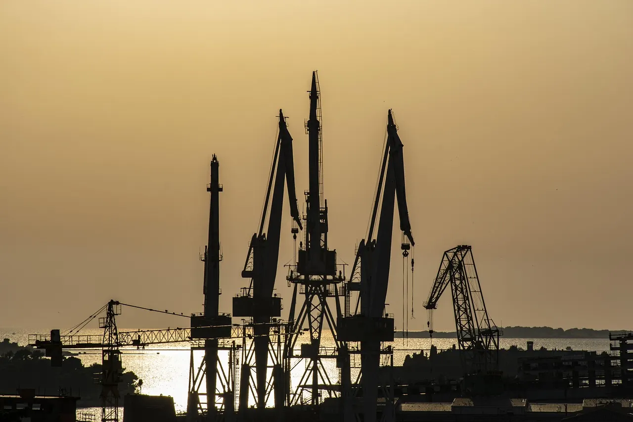 Silhouetten van de havenkranen van de Uljanik-scheepswerf in Pula bij zonsondergang boven zee