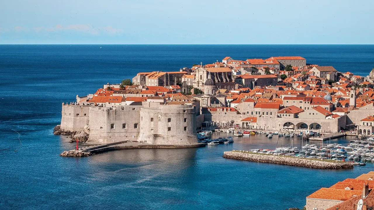 Ommuurde oude stad van Dubrovnik met oranje daken, vestingwerken en haven aan de blauwe Adriatische Zee