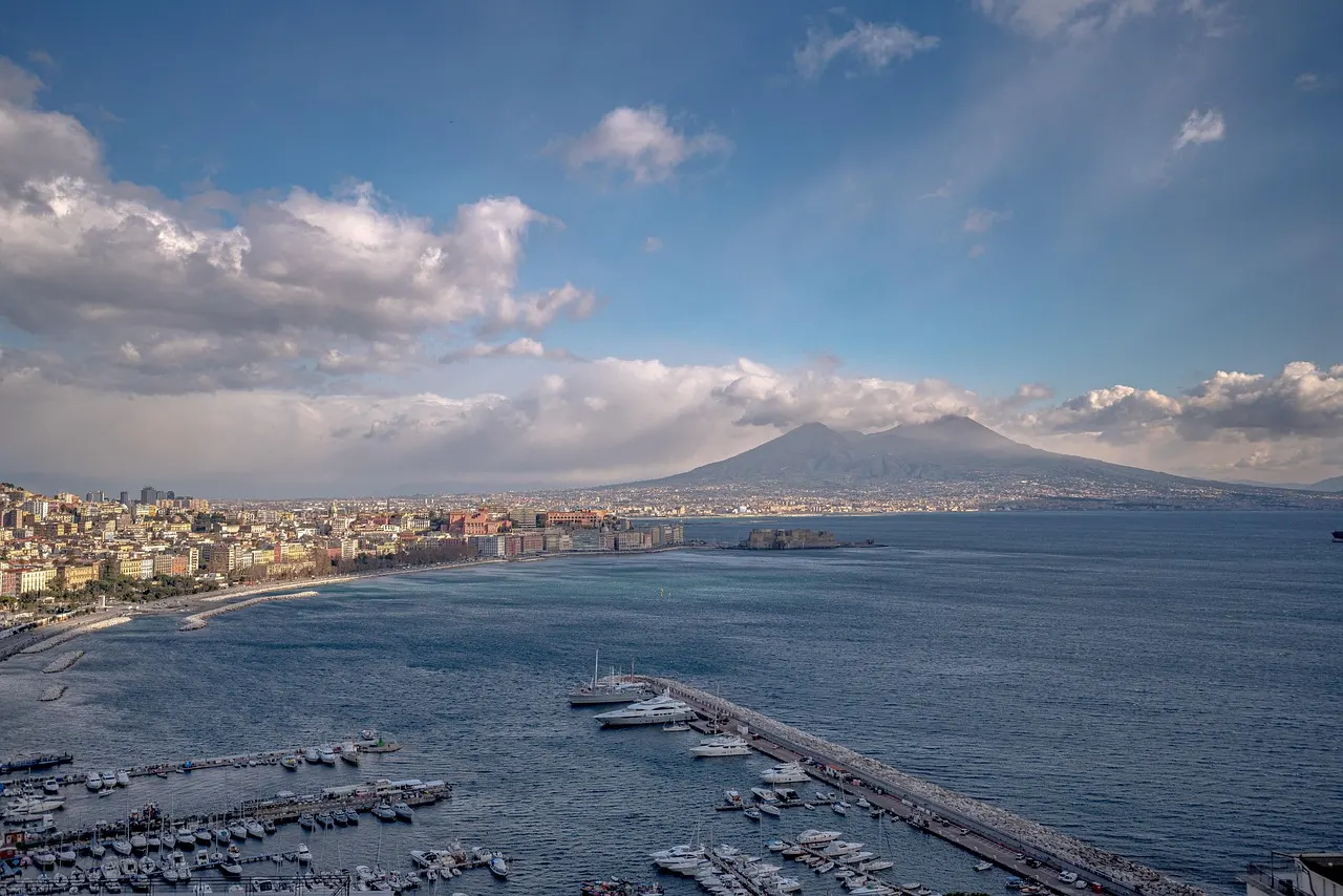 Uitzicht over de baai van Napels met jachthaven, de stad aan het water en de Vesuvius op de achtergrond