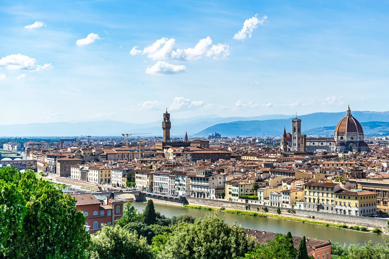 Panorama van Florence met de Arno, Palazzo Vecchio en de koepel van de Duomo onder een blauwe lucht