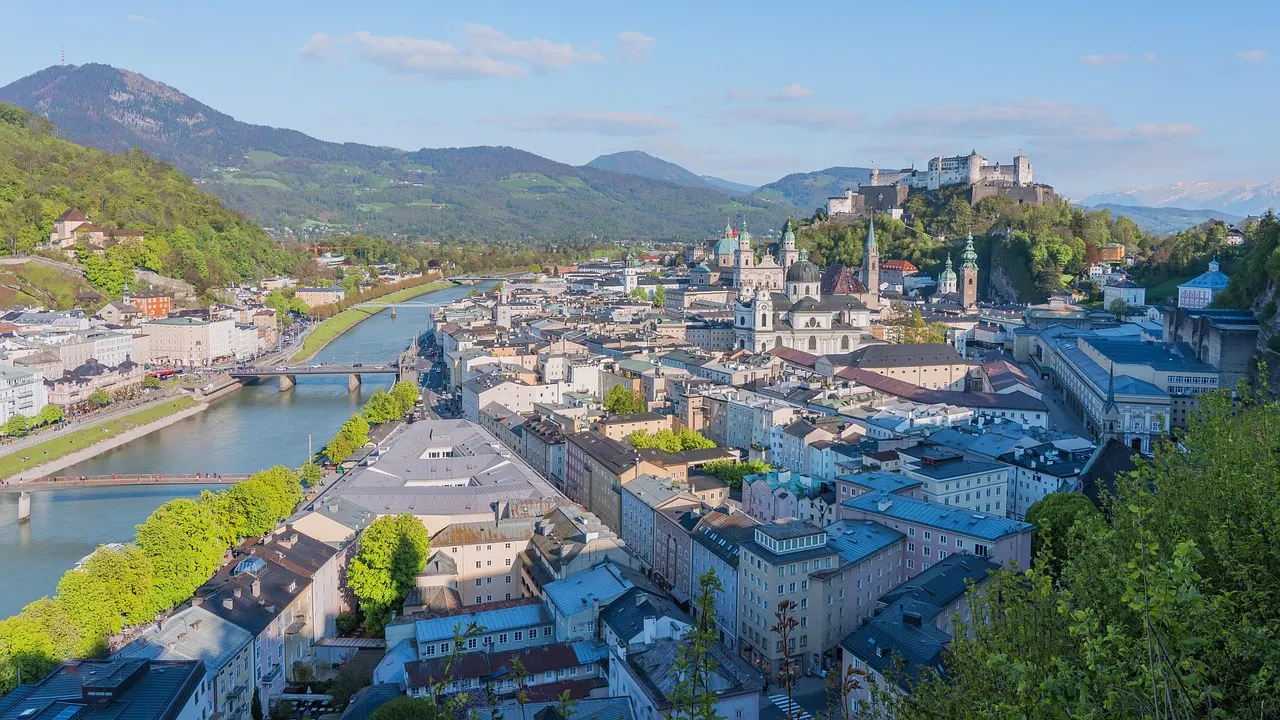 Zicht over de oude binnenstad van Salzburg en de Salzach met de vesting Hohensalzburg op de heuvel