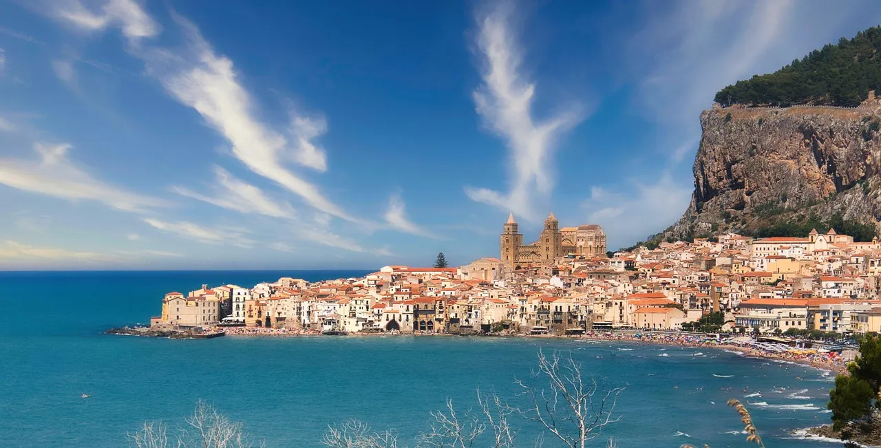 Kustplaats Cefalù met kathedraal en rots aan de blauwe zee op Sicilië