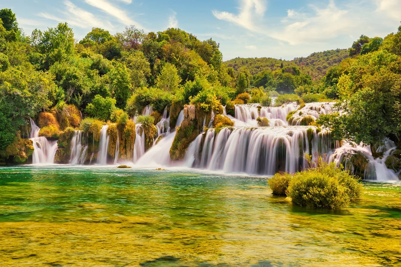 Brede cascade van Skradinski Buk bij de Krka watervallen met groen water en bebost landschap