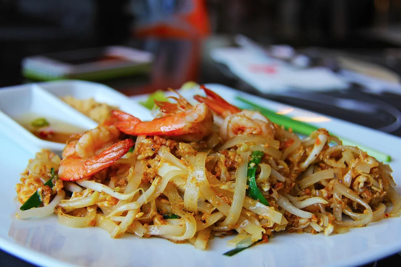 Bord Pad Thai met platte rijstnoedels, garnalen, taugé en lente-ui