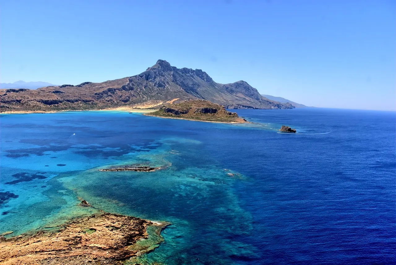 Turquoise en diepblauwe zee bij de baai van Balos met het bergachtige Gramvousa-schiereiland op Kreta