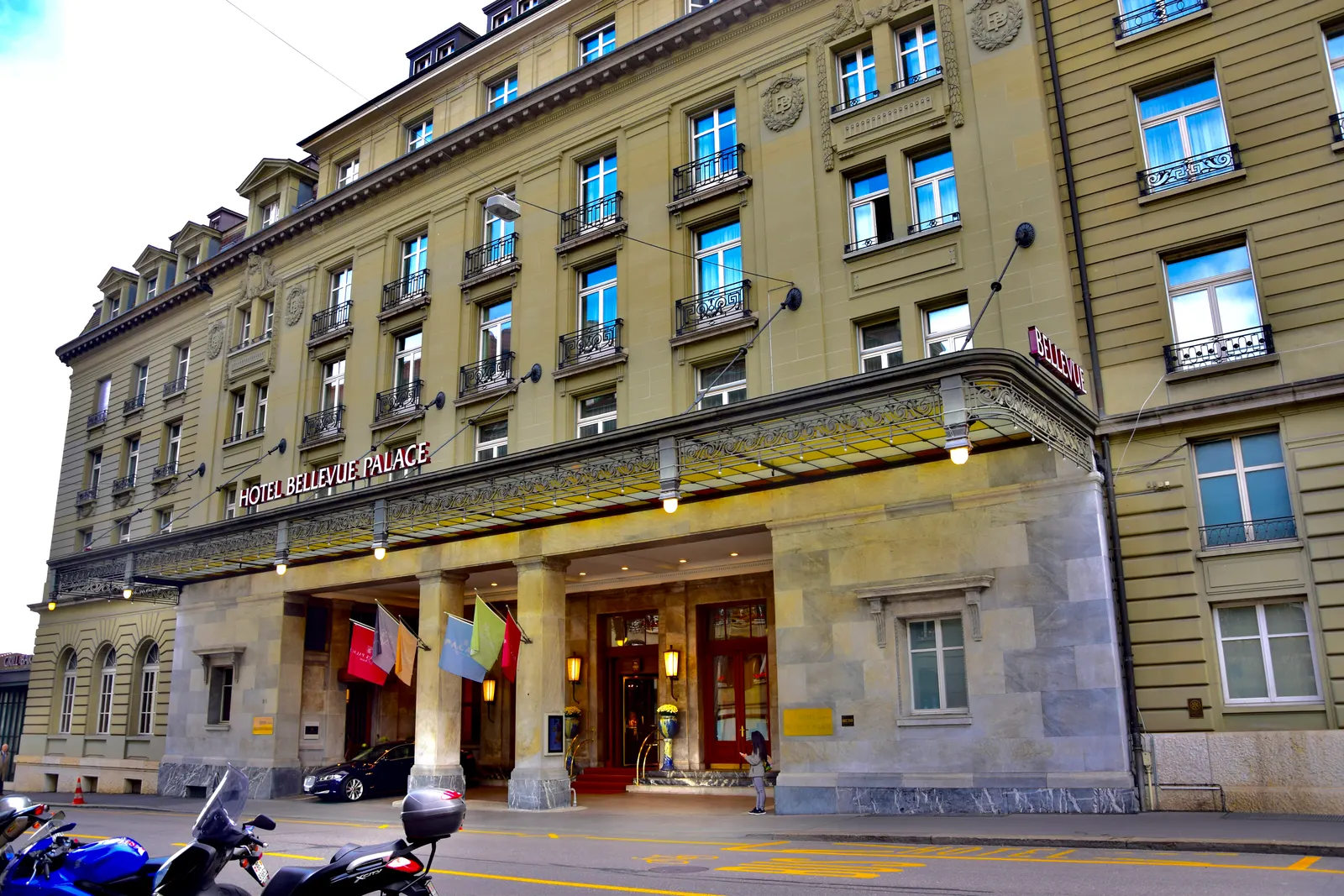 Statige gevel en ingang met vlaggen van Hotel Bellevue Palace in Bern