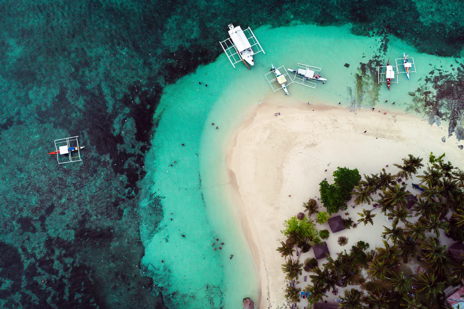 Luchtfoto van een wit zandstrand met palmbomen, turquoise water en bangka-boten bij Siargao