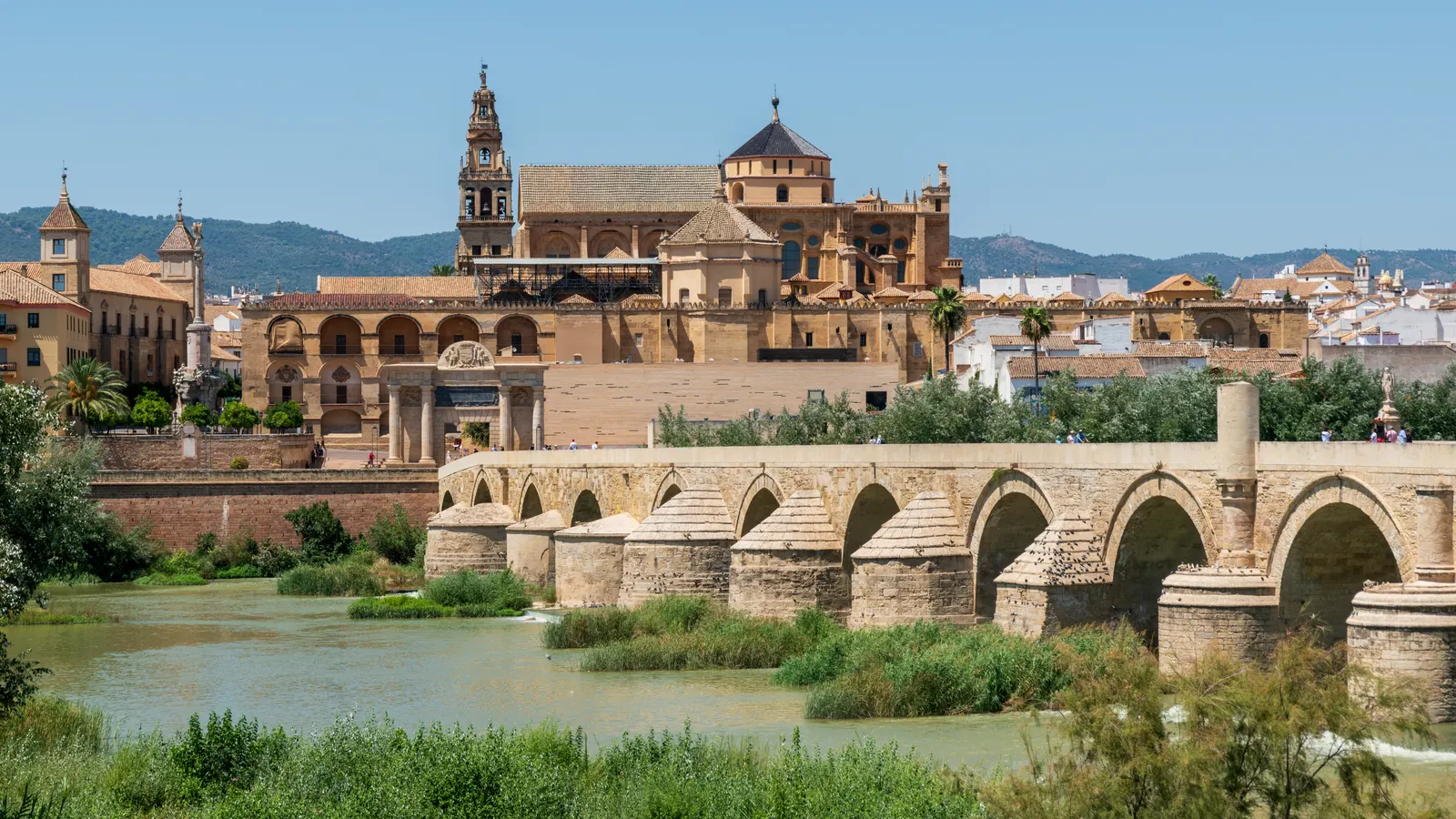 De Mezquita van Córdoba met klokkentoren achter de Romeinse brug over de rivier de Guadalquivir