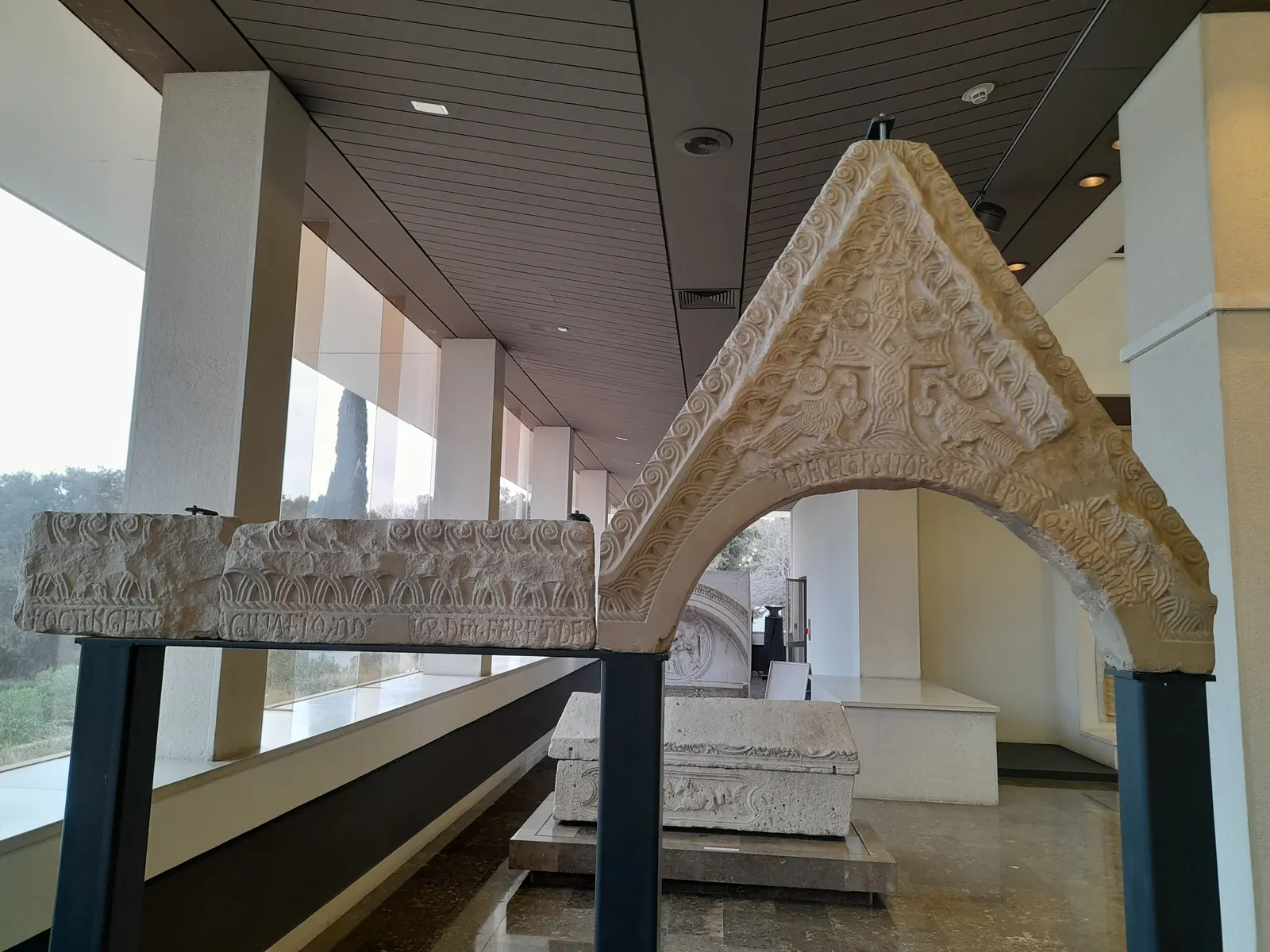 Middeleeuwse stenen gevel met vlechtwerkversiering in een lichte museumgalerij