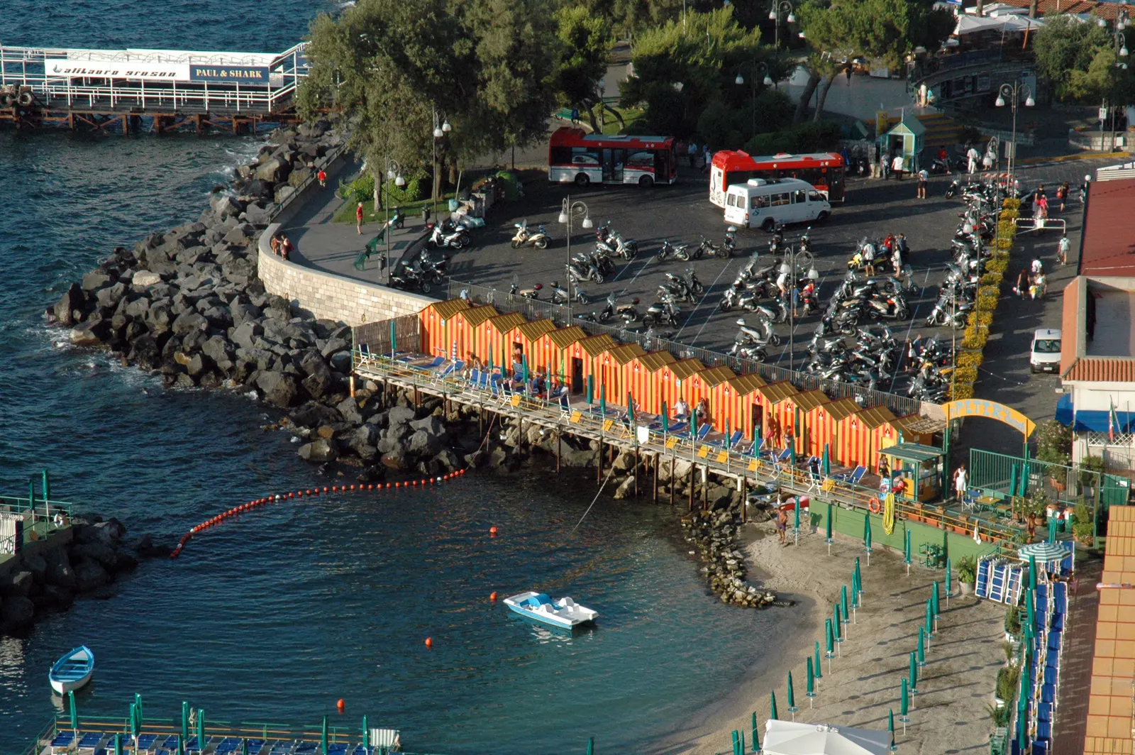 Uitzicht van bovenaf op de jachthaven Marina Piccola van Sorrento met oranje strandcabines en de baai