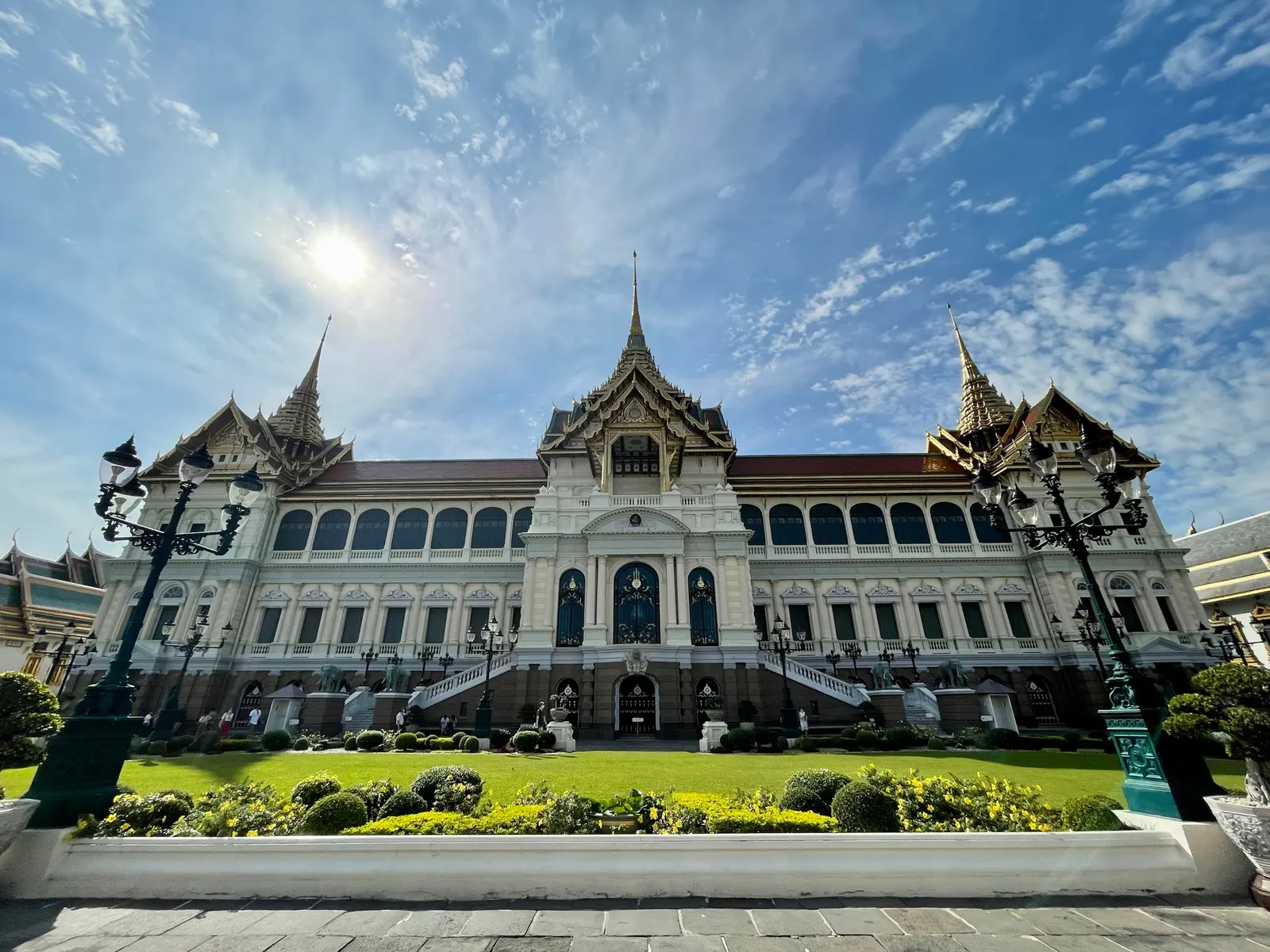 Het Chakri Maha Prasat-paleis van het Grand Palace in Bangkok met gazon en blauwe lucht