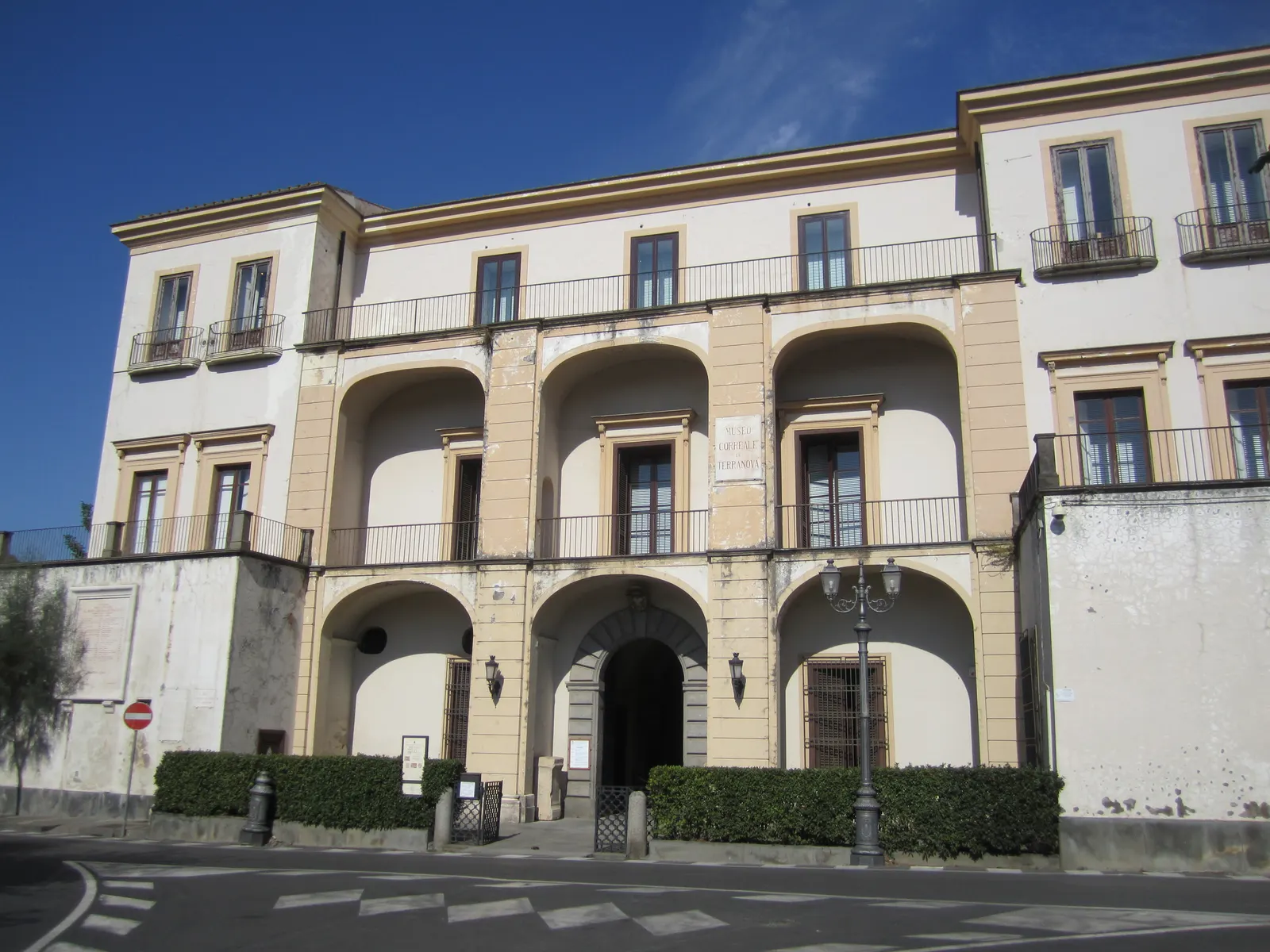 Lichte gevel van het Museo Correale di Terranova in Sorrento met boogportalen en balkons onder een blauwe lucht
