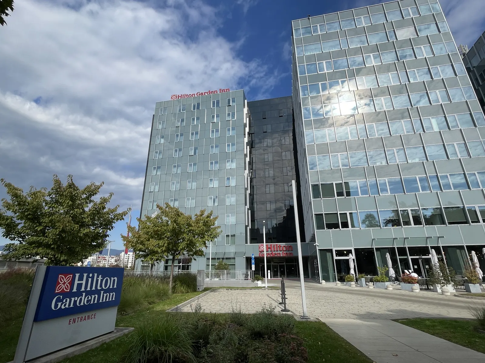 Moderne glazen gevel van het Hilton Garden Inn Zagreb aan de Radnička met naambord bij de ingang