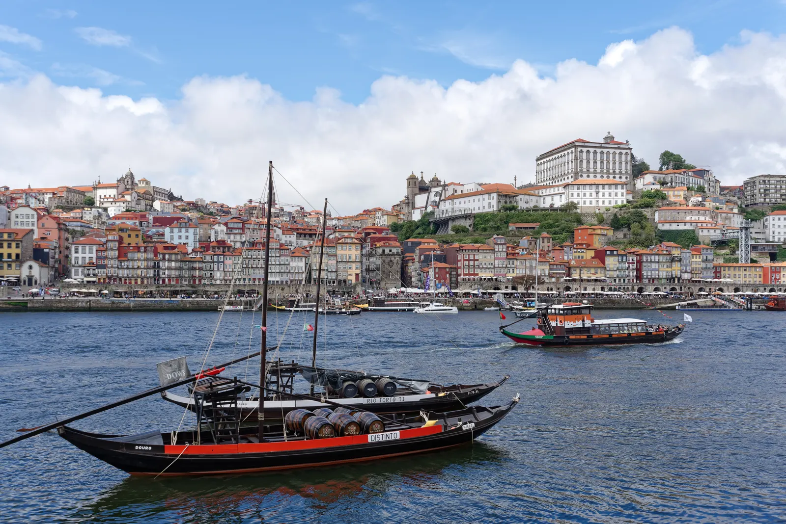 Rabelo-boten met portvaten op de Douro voor de kleurrijke Ribeira-kade in Porto