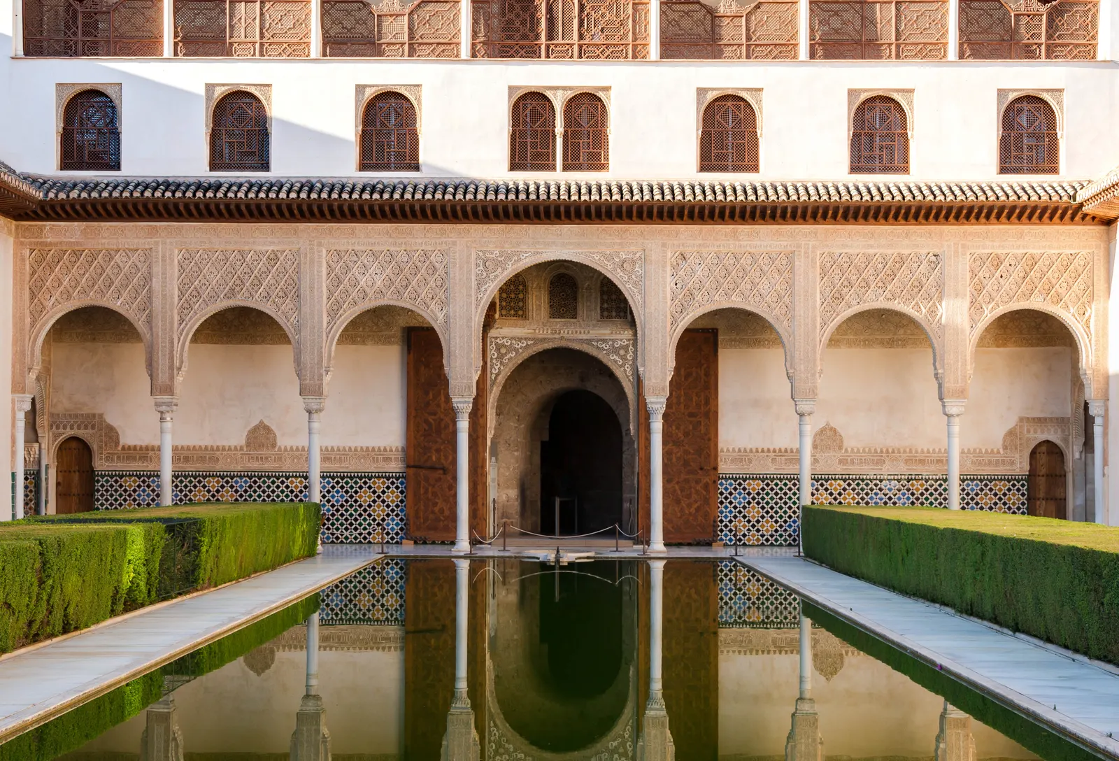 Hof van de Mirten in het Alhambra met weerspiegelende vijver, gesneden bogen en strak geknipte hagen