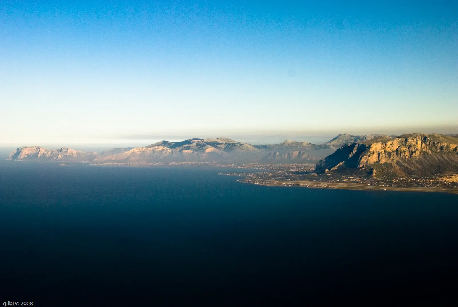 Luchtfoto van de rotsachtige kaap Capo Gallo en de bergen langs de kust bij Palermo, met diepblauwe zee