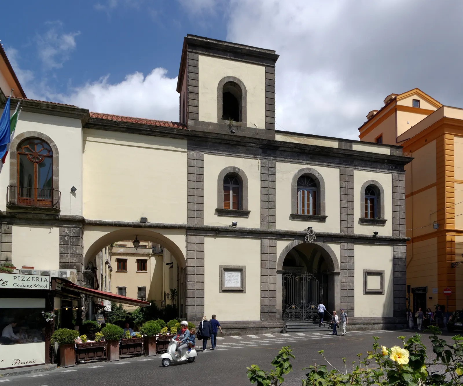 Gevel van de Basiliek van Sant'Antonino in Sorrento met boogpoorten en een klokkentorentje onder blauwe lucht