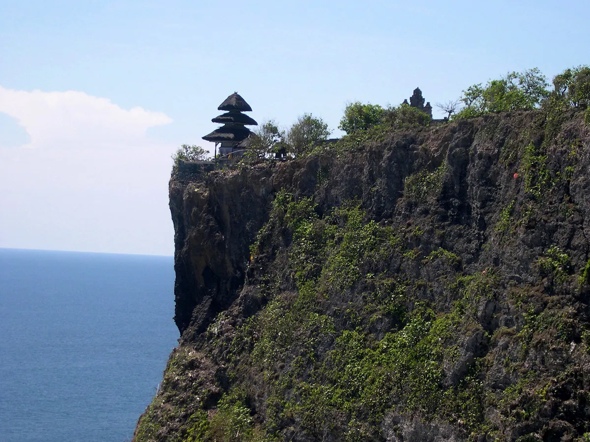 Pura Luhur Uluwatu-tempel op de rand van een steile, begroeide klif boven de blauwe Indische Oceaan