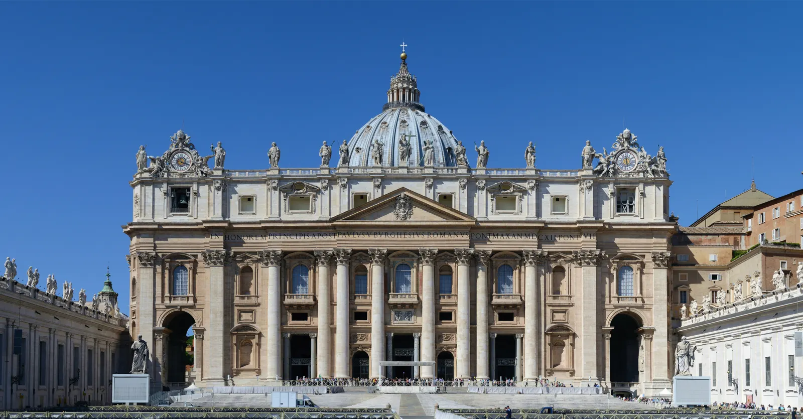 Gevel en koepel van de Sint-Pietersbasiliek in Rome onder een strakblauwe lucht