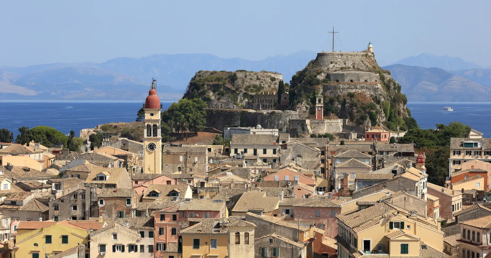 Oude stad van Corfu met kleurrijke huizen, rode klokkentoren en het oude fort op de rots aan zee