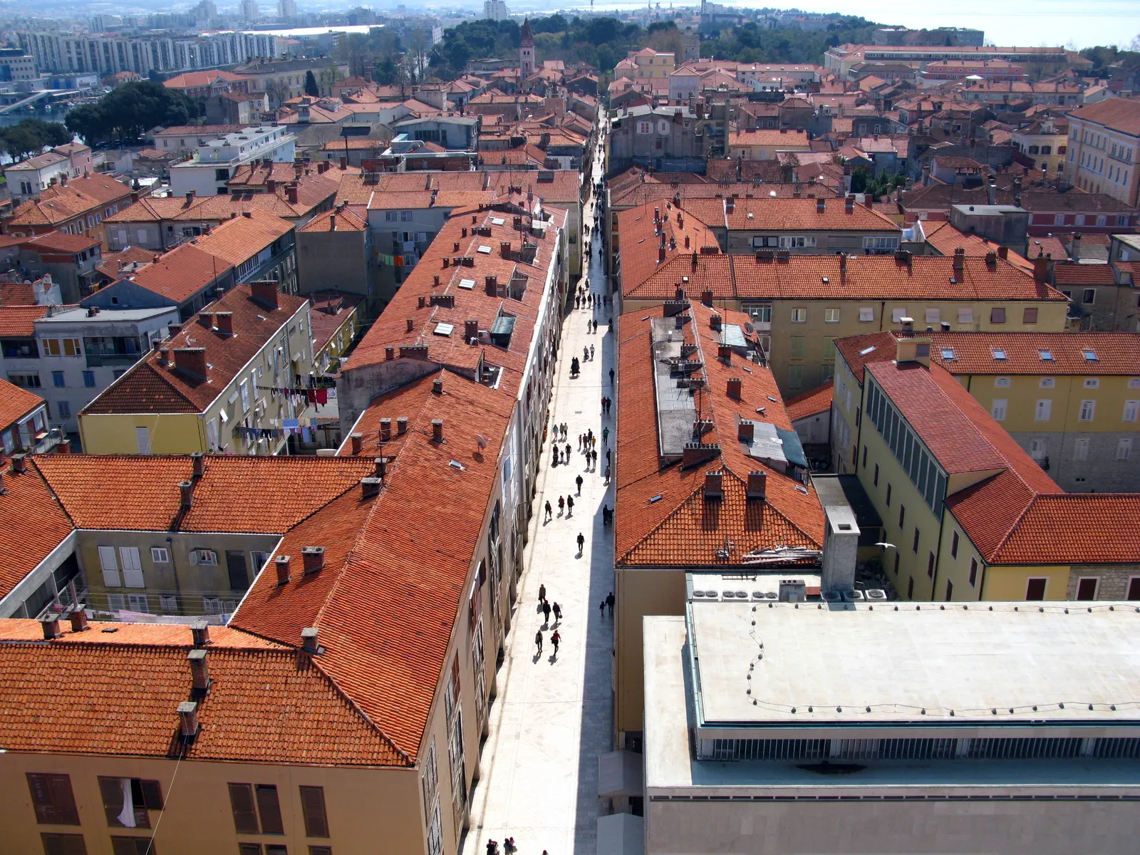 Uitzicht van bovenaf op de Kalelarga, de drukke hoofdstraat van Zadar tussen oranje daken